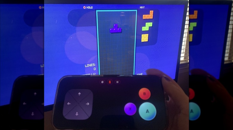 "Tetris Time Warp" gameplay on TV screen with smartphone controller in foreground