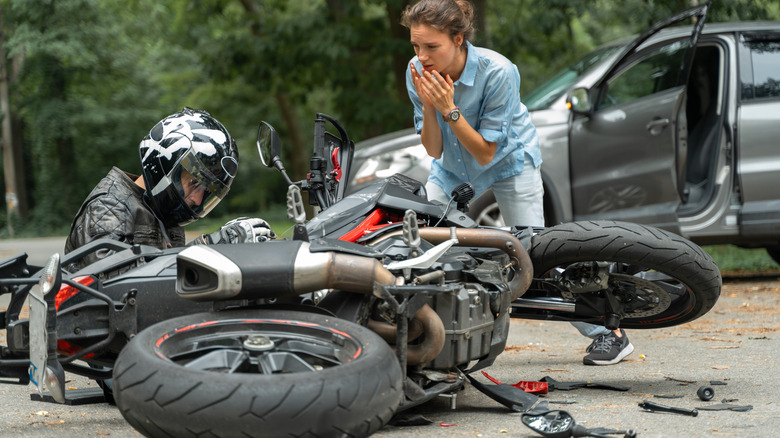 Rider and driver react to motorcycle and car crash.