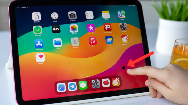 An iPad screen with a black spot up front and an arrow pointing toward it