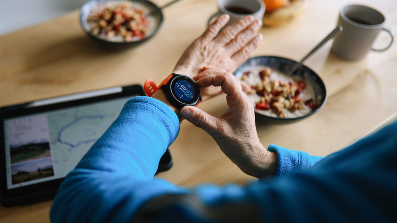 Person looking at their smartwatch over a kitchen table