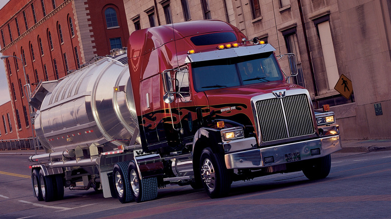 Western Star 4900-series driving with tanker trailer on urban road, front-right view