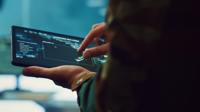 Sailor using tablet to monitor data feeds