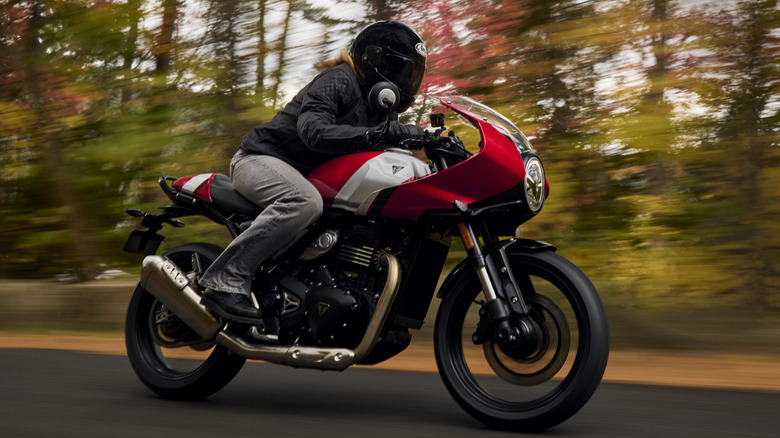 Front 3/4 view of Triumph Thruxton 400 on road in forested setting