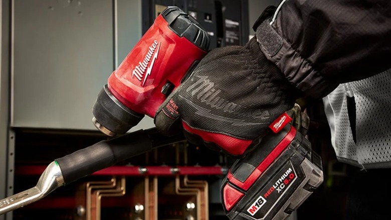 Person using Milwaukee heat gun on rubber