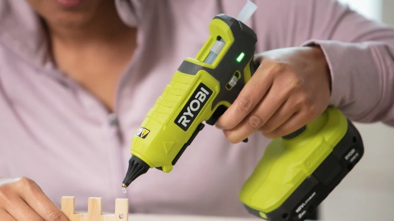 Person holding Ryobi glue gun on a craft project