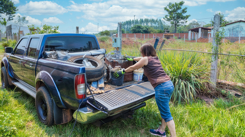 Woman moving things out of the bed of a truck