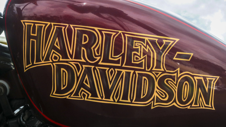 Maroon harley davidson fuel tank with yellow lettering