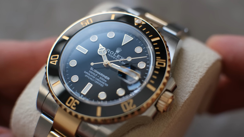 Dealer holding up a Rolex watch