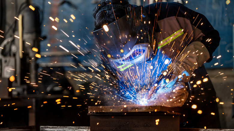 A worker welding a piece of metal