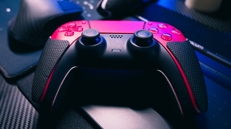 A PS5 controller on a computer desk.