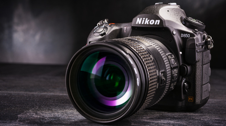 A Nikon D850 camera sitting on a black surface