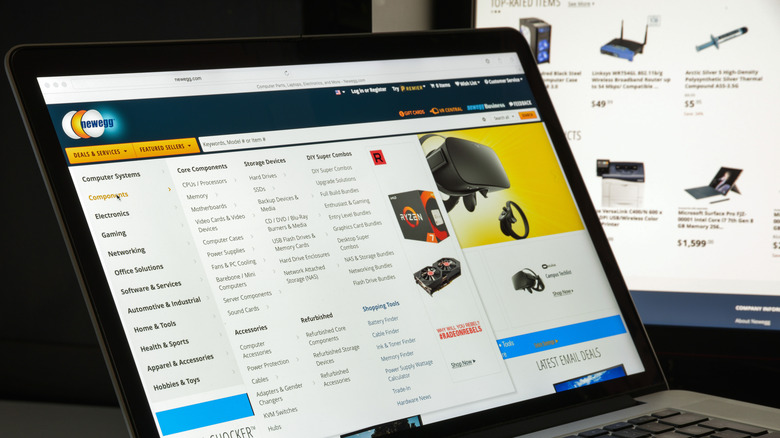 The Newegg website on a laptop in front of another computer monitor