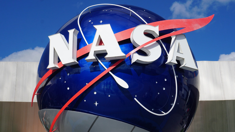 NASA logo on a blue metal globe outside with a blue sky in the background.