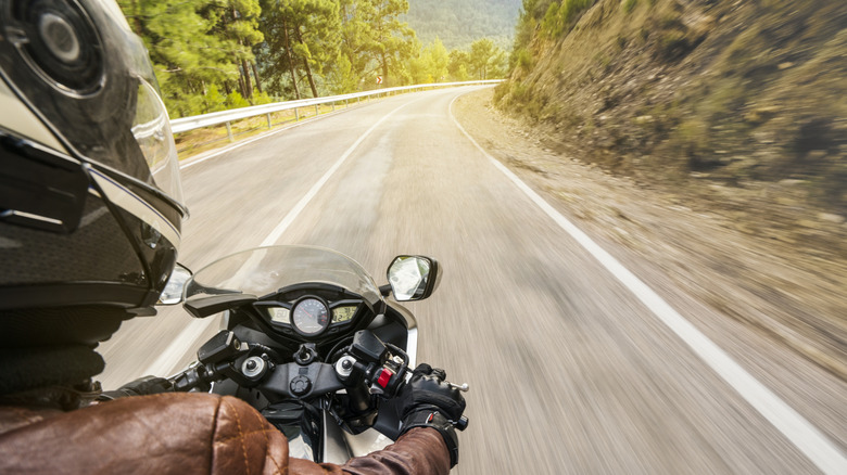 A rider riding his motorcycle in the center of the lane.